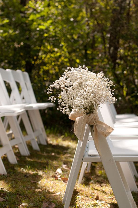 white chairs accented with baby's breath and burlap bows to style your wedding aisle in a very chic and glam way