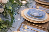 23 a pretty wedding tablescape with a periwinkle table runner, napkins, periwinkle plates, pastel blooms and candle lanterns
