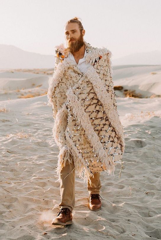 a neutral desert groom's look with a bold accent - an embellished Moroccan wedding blanket as a cover up is jaw-dropping