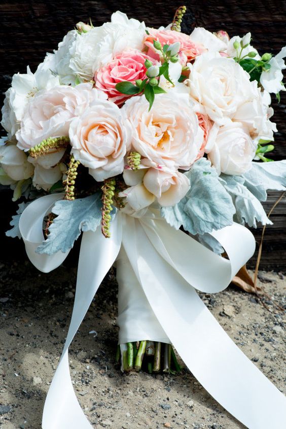 a classic wedding bouquet with blush, pink and white blooms, pale foliage and a white ribbon bow is amazing