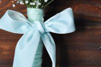 26 a delicate wedding bouquet of baby’s breath, aqua yarn and an aqua bow of ribbon for a bride or a bridesmaid