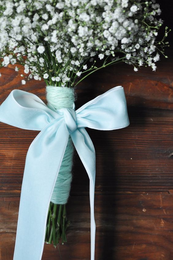 a delicate wedding bouquet of baby's breath, aqua yarn and an aqua bow of ribbon for a bride or a bridesmaid