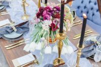 26 a sophisticated periwinkle wedding tablescape with a peri table runner, napkins, a bold floral centerpiece, black candles and gold touches