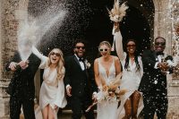 27 the couple and their friends wearing white and black and white outfits and rocking white dried bloom bouquets for a modern wedding