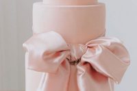 29 a large pink wedding cake with a large pink silk bow of ribbon is a gorgeous idea for a refined wedding done with pastel colors