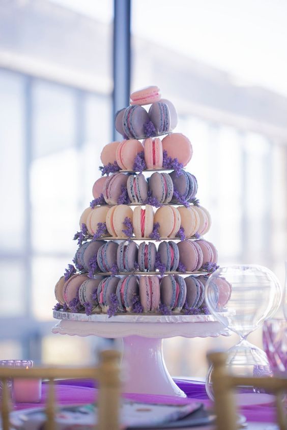 a tower of neutral, blush and periwinkle macarons decorated with blooms is a gorgeous alternative to a usual wedding cake