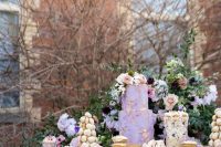 37 a gorgeous and refined wedding sweets table with a textural lilac and floral wedding cake, a couple of croquembouches, cupcakes and other delicious desserts