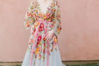 38 a blush A-line wedding dress with colorful floral embroidery, a plunging neckline, long sleeves and a pink sash for a garden wedding