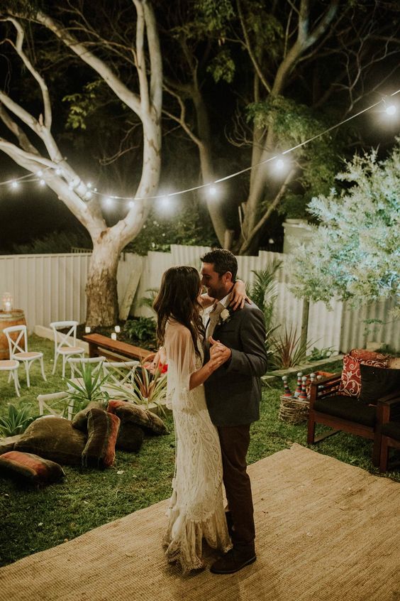 an intimate backyard garden wedding with simple and cozy boho decor and string lights is a cute idea