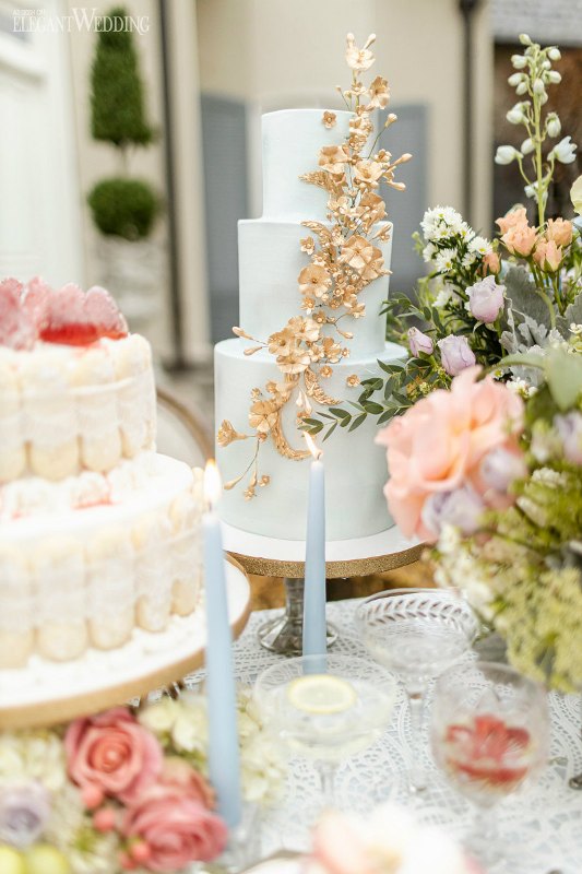 a refined Bridgerton wedding cake in pastel blue and with gilded bloming branches is a very beautiful idea