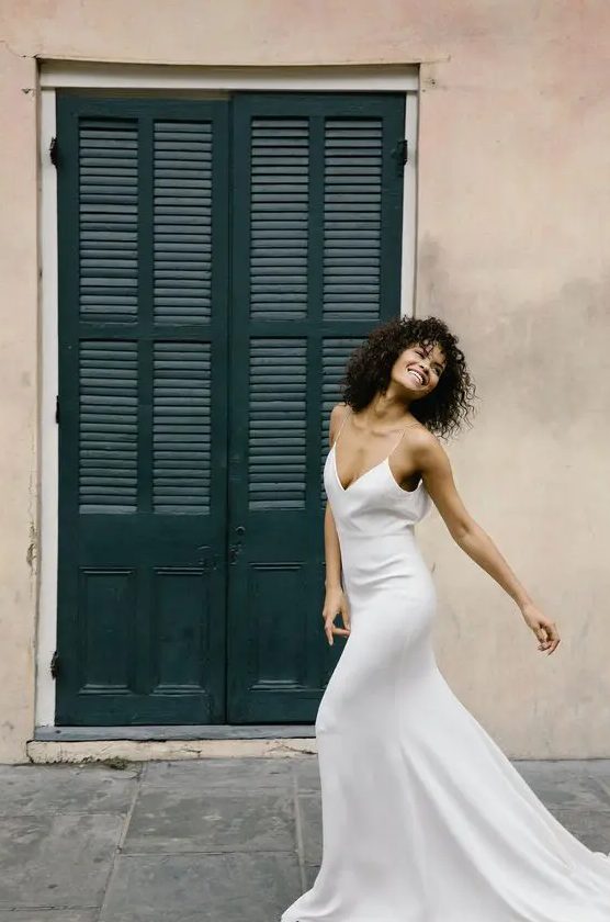 A light slip wedding dress with a highlighted waistline and a train is classics for summer