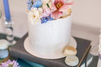 44 refined and delicate wedding sweets – mini cakes and a large textural white one, all topped with fresh blooms