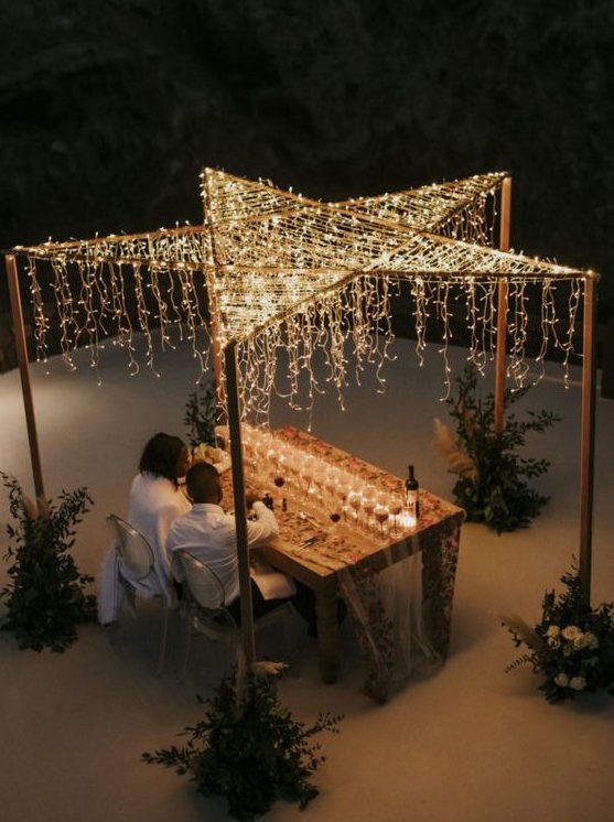 a star-shaped canopy of lights with some hanging lights is a pretty idea for a micro wedding or an elopement