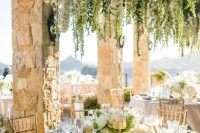 48 a refined neutral wedding tablescape with a lush hanging floral chandelier with greenery over it to make a bold statement
