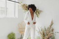 55 a killer bridal pantsuit with a deep neckline and fitting pants, white shoes and statement earrings