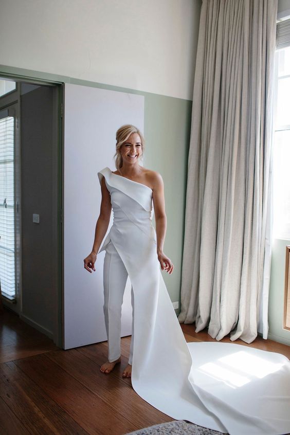 a modern bridal jumpsuit - a one shoulder one and a skirt with a train on the side is a wow idea