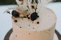 59 a neutral buttercream wedding cake with speckles, blackberries and dried blooms and grasses
