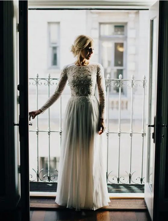 a high neckline long sleeve wedding dress with an embroidered and embellished bodice and a plain skirt