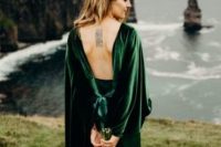 a beautiful green fitting wedding dress with an open back, bell sleeves and a layered skirt is a gorgeous idea for a modern wedding