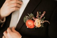a black blazer refreshed with a pocket square with yellow and orange ranunculus, thistles, berries, greenery and astilbe