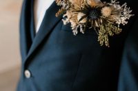 a black blazer with a floral pocket square styled with dried blooms and grass, a thistle is a pretty idea for a boho groom