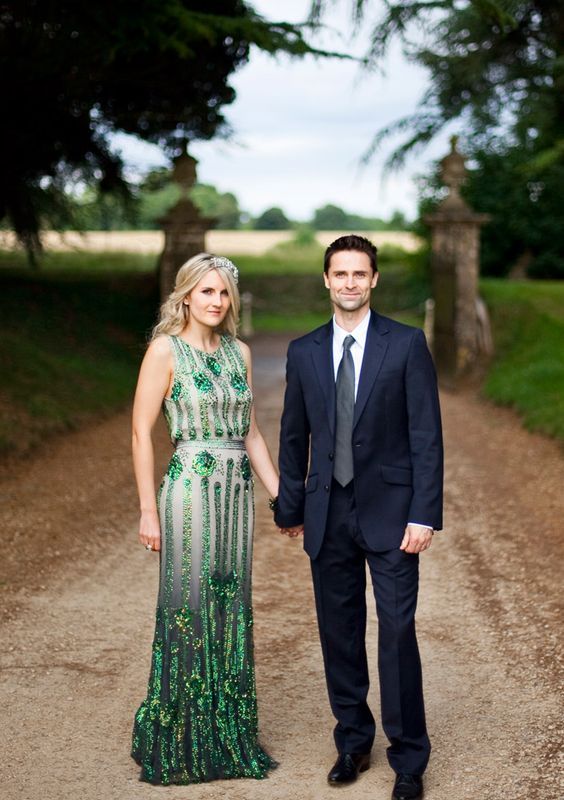 a bold emerald embellished fitting wedding dress with no sleeves, a high neckline and a small train is a very chic idea