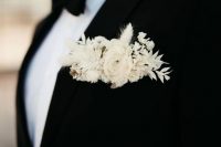 a classic black tux with a contrasting pocket square done with white dried blooms and grasses for a super elegant and modern feel