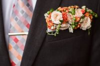 a dark brown blazer, a bright geo print tie, a bold floral pocket square with blush, orange blooms and green berries for a bolder look