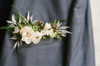 a grey plaid blazer and a neutral floral pocket square with greenery and berries for a fresh and edgy touch in the look