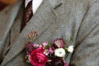 a grey tweed blazer and a pocket square styled with deep purple, white and pink blooms and berries for a touch of jewel tones