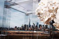 a modern clear acrylic wedding arch with no decor at all and with a view of a big city as a backdrop is a gorgeous idea