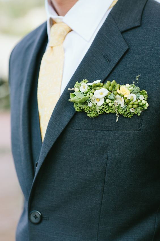 a slate grey blazer refreshed with a yellow tie and a pocket square with white and yellow blooms, greenery and succulents