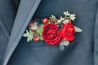 a slate grey blazer with a colorful pocket square done with hot red blooms, berries, succulents and thistles for a bold accent