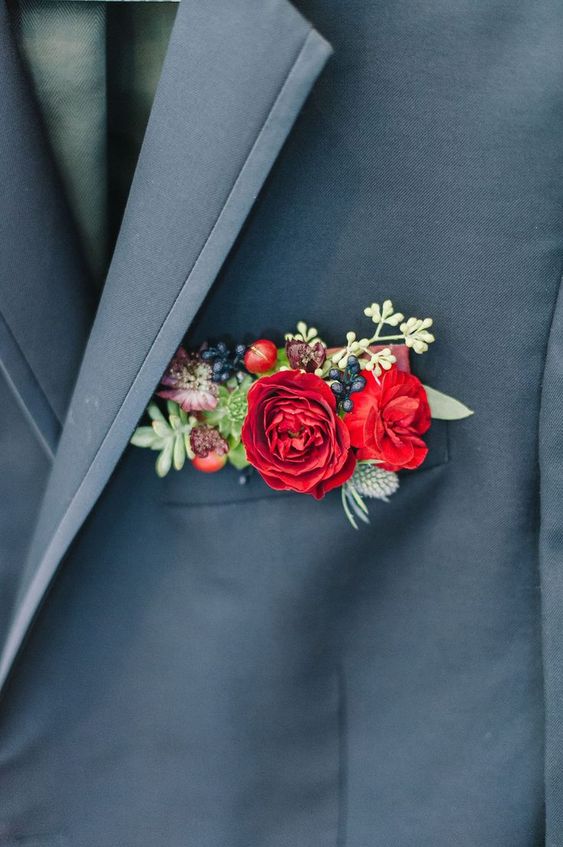 a slate grey blazer with a colorful pocket square done with hot red blooms, berries, succulents and thistles for a bold accent