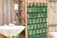 a small boxwood wall in a stained wooden frame, with comfortable stands is a cool idea for a rustic wedding