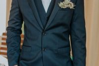 a stylish grey three-piece suit and a pocket square accented with thistles and waxflower for a whimsical and fresh touch in the look