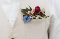 a tan waistcoat styled with a blue, white, burgundy blooms, leaves and tiny peppers is a cool and unexpected idea of detailing