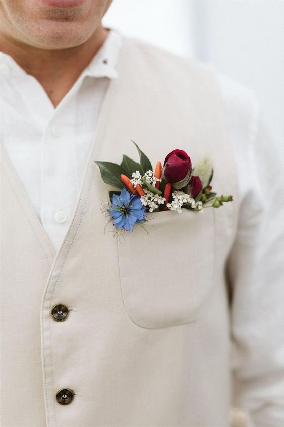 a tan waistcoat styled with a blue, white, burgundy blooms, leaves and tiny peppers is a cool and unexpected idea of detailing
