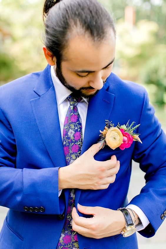 an electric blue blazer, a bold colorful floral tie, a bold pocket square with hot pink, yellow blooms and greenery for a colorful look