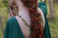 an elvish bridal look with a green dress with a deep cut back, with a large twisted braid and greenery touches