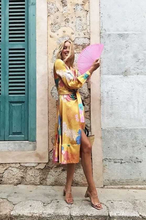 a bold yellow silk midi wrap dress with bright floral prints, nude square toe shoes for a bright summer wedding