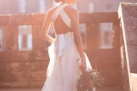 07 a chic A-line wedding dress with a ruffle skirt and a criss cross back plus a bow on the back is amazing