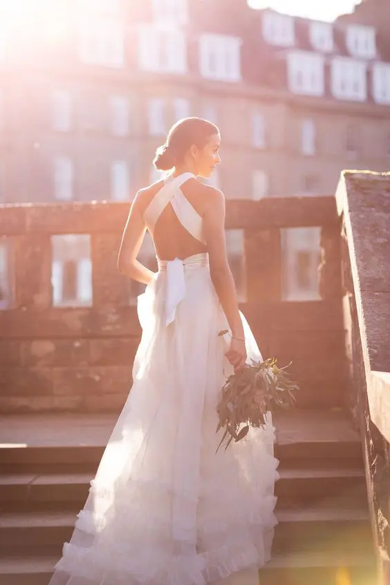 a chic A line wedding dress with a ruffle skirt and a criss cross back plus a bow on the back is amazing