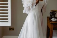11 a beautiful off the shoulder A-line wedding dress with ruffles on the sleeves and overskirt plus a train is wow