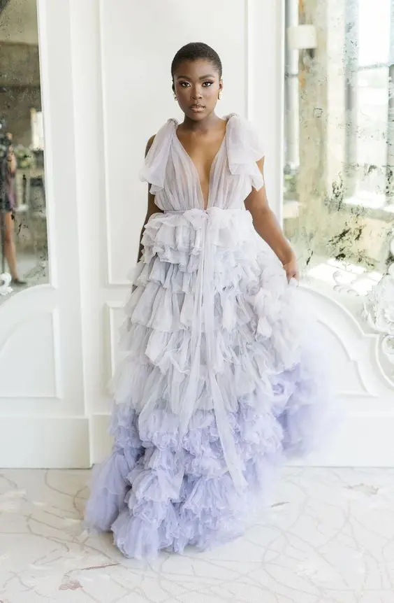 a beautiful lilac A line wedding dress with a tulle bodice, tulle bows on the shoulders and ruffle tier skirt with a train