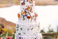 13 a multi-tier white wedding cake with pressed bold blooms, a tier with only leaves and a painted lilac tier is amazing for summer