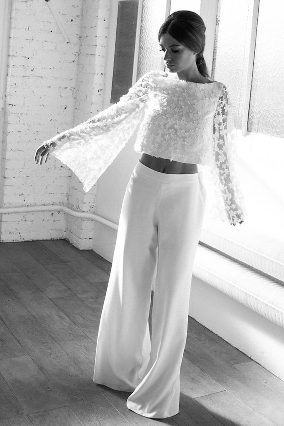 a beautiful bridal outfit with a lace applique crop top with bell sleeves, white plain wideleg pants feels like the 70s