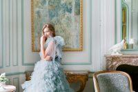 21 an aqua-colored tulle wedding dress with large tulle bows on the shoulders and tiers of tulle ruffles that compsoe the skirt is wow