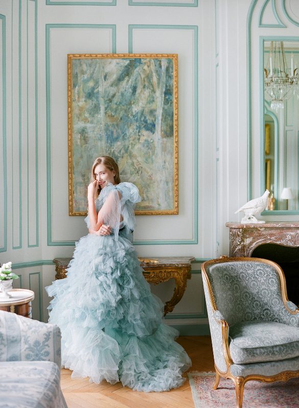 an aqua-colored tulle wedding dress with large tulle bows on the shoulders and tiers of tulle ruffles that compsoe the skirt is wow