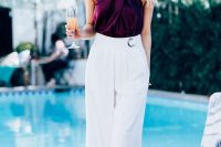 27 a bold summer wedding guest outfit with a deep purple criss cross top, white wideleg pants with pleating and statement earrings